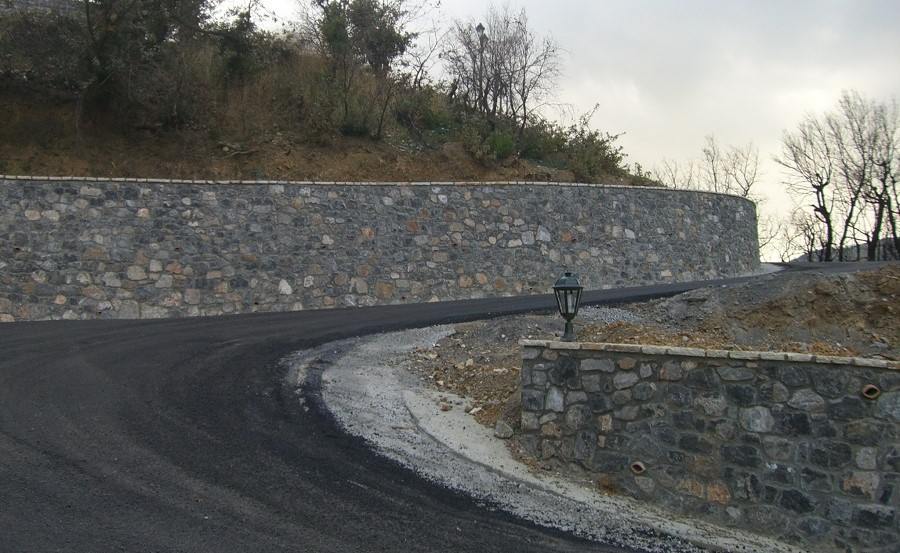 Πέτρινο τοιχείο και ασφαλτόστρωση του δρόμου στον λόφο του Νικηταρά